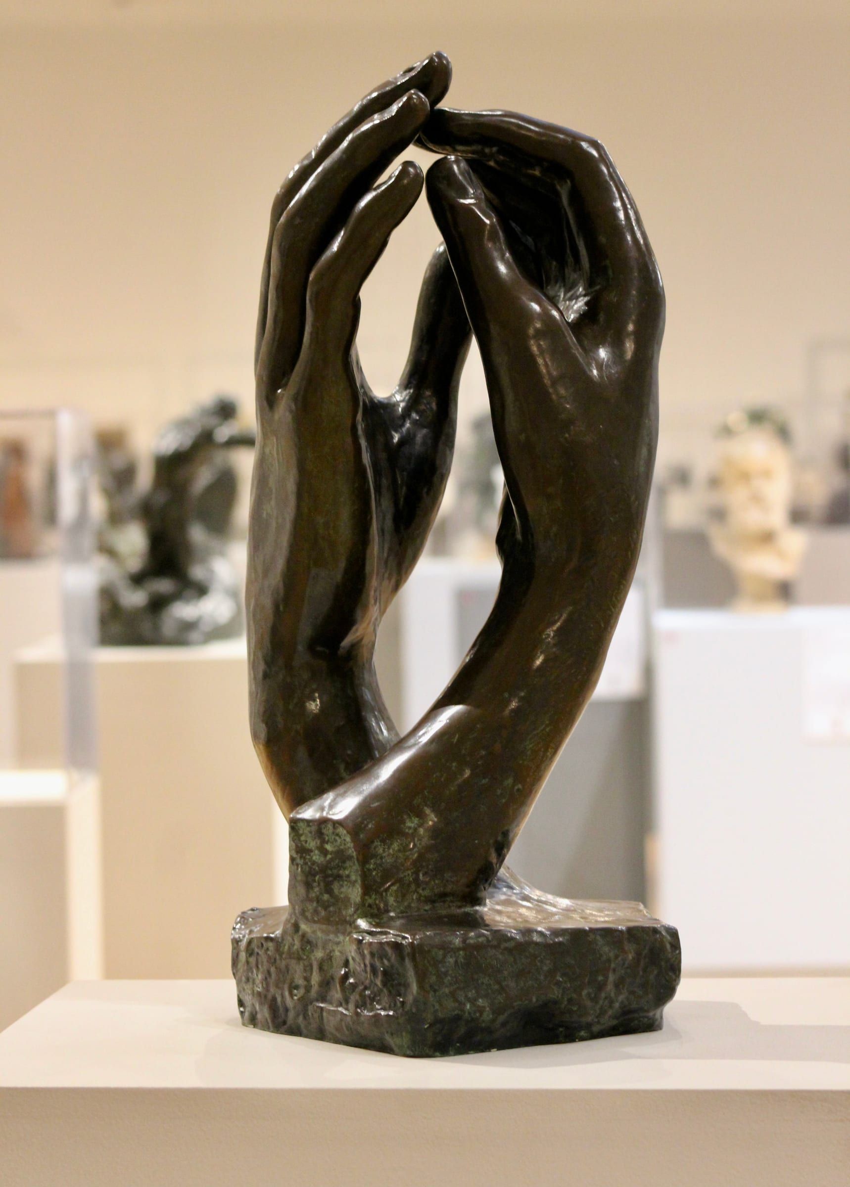 Dos manos en bronce sobre un pedestal