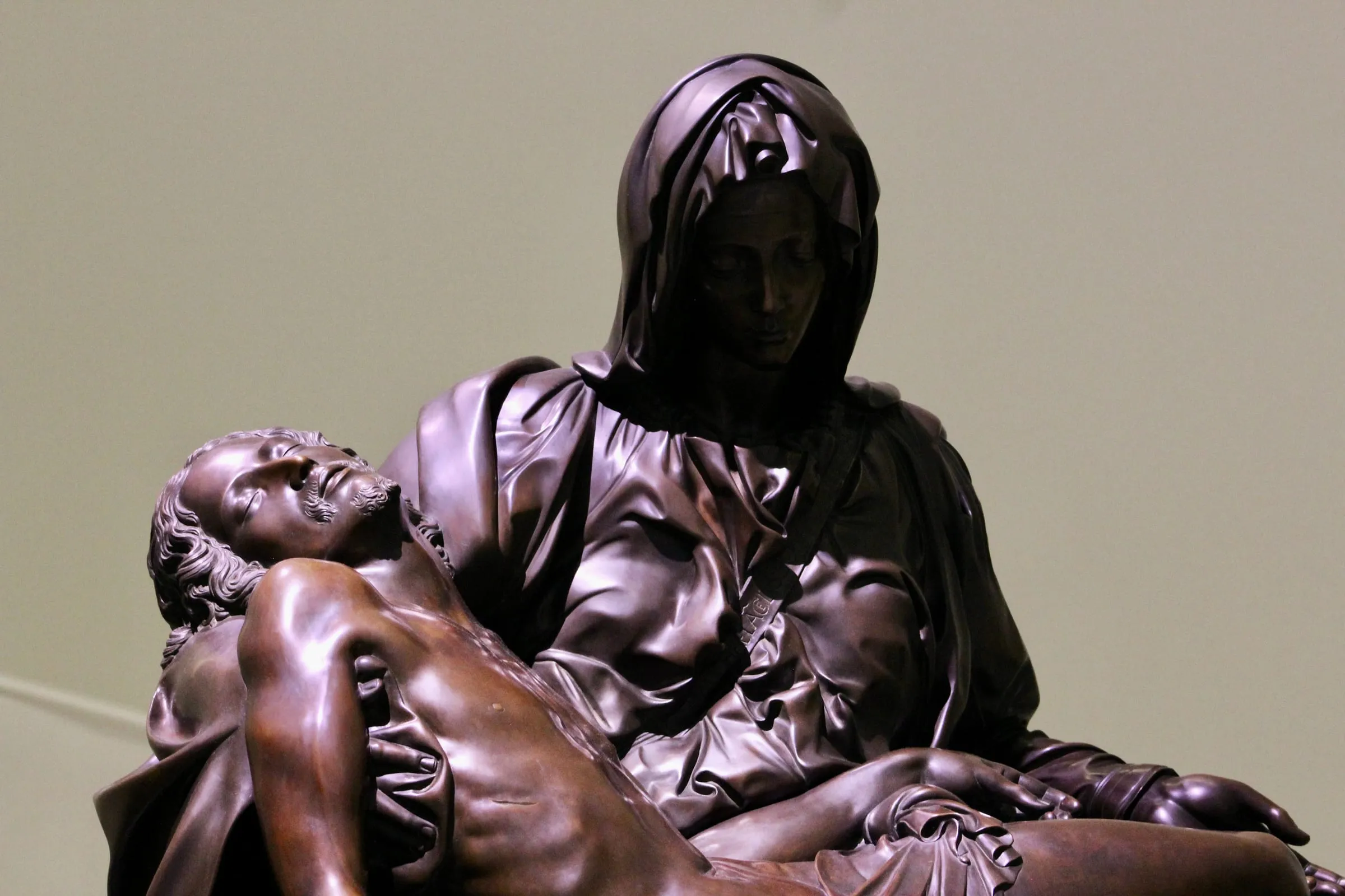 La Piedad en bronce oscuro dentro de una sala de museo