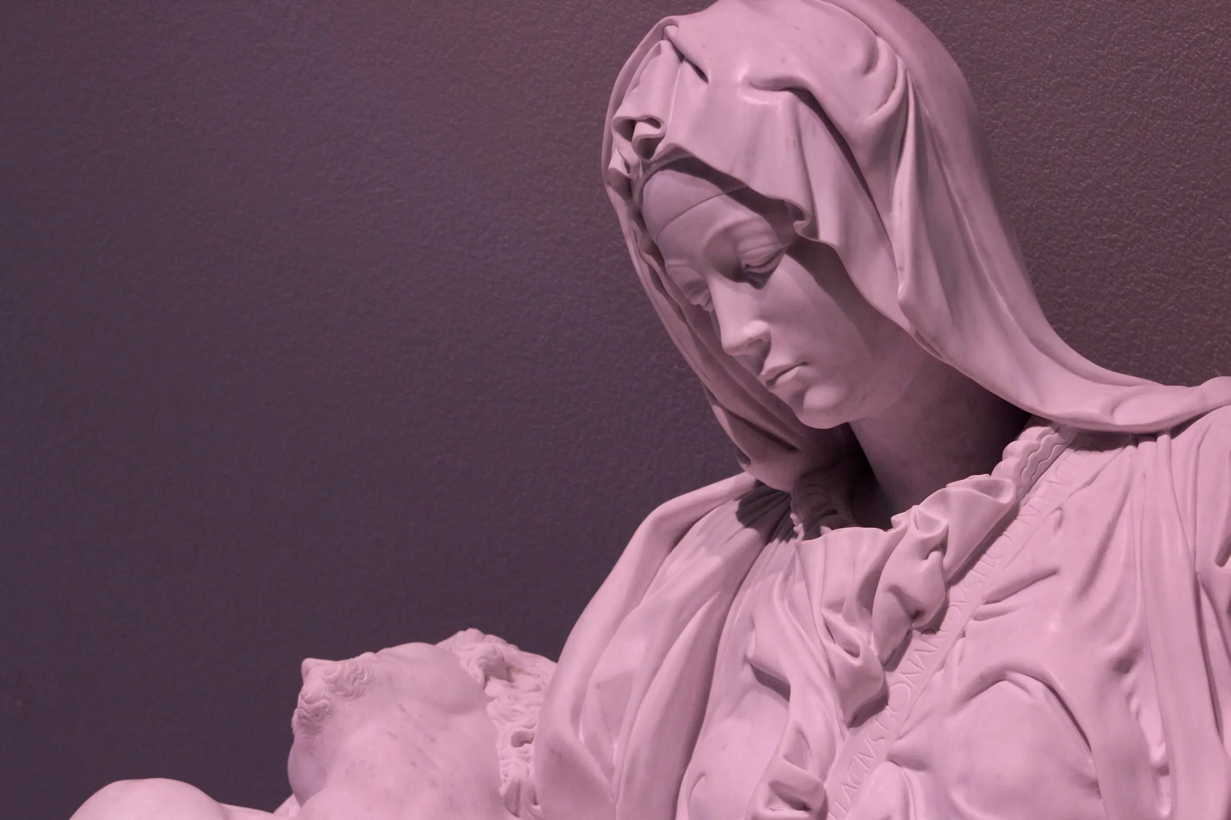 Escultura de la Piedad bañada en luz rosada