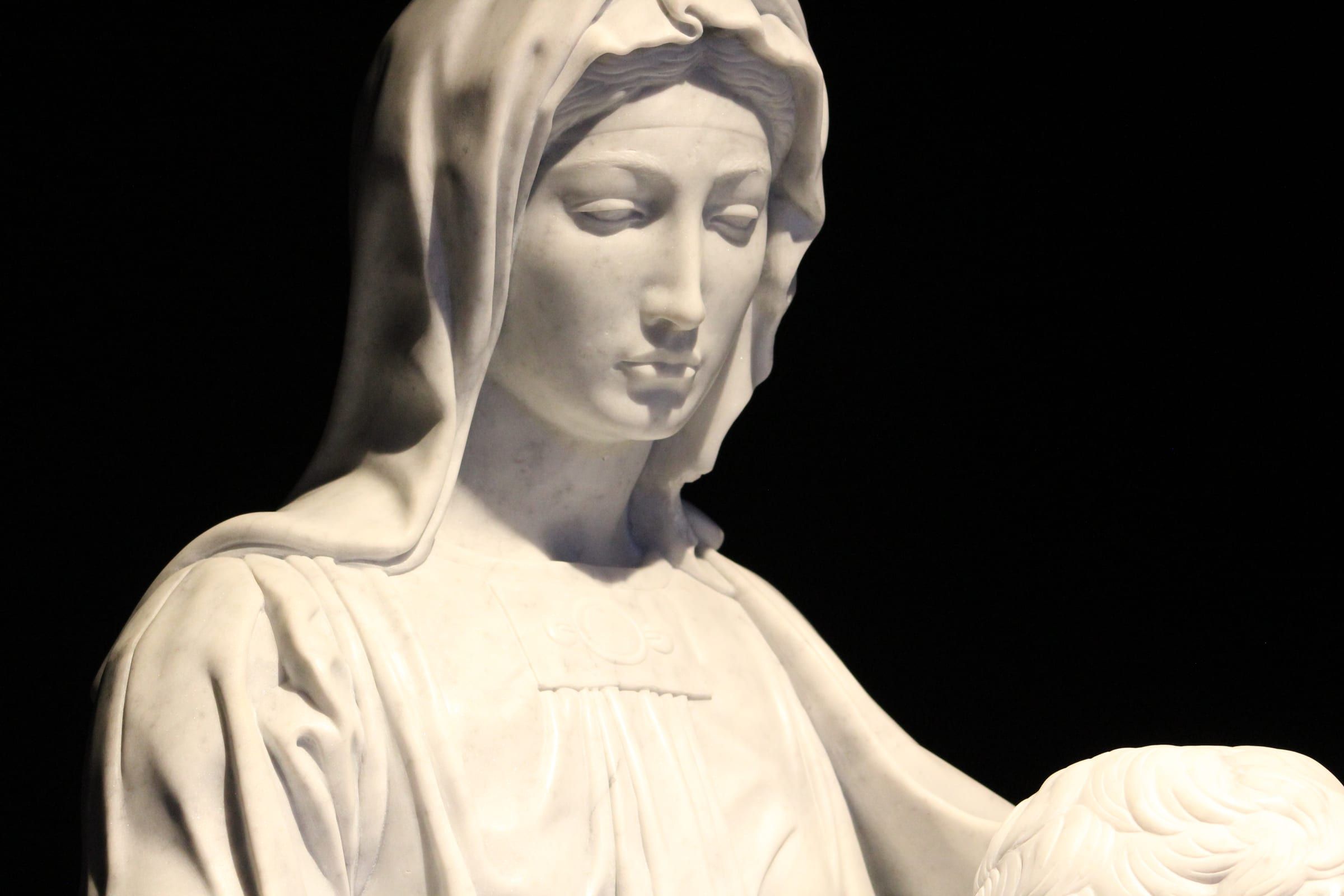 Rostro sereno en mármol iluminado sobre fondo negro
